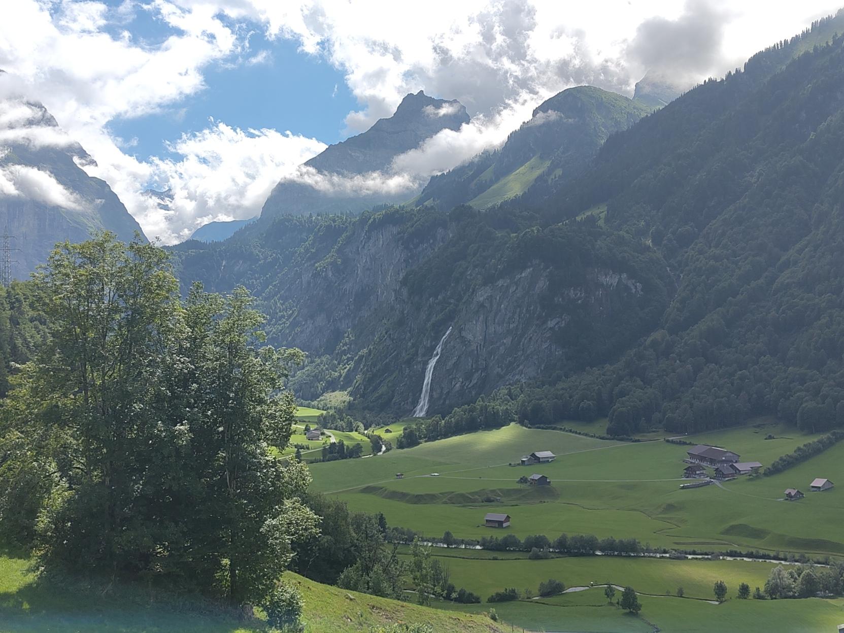 A valley with a bigger waterfall coming down from the mountain