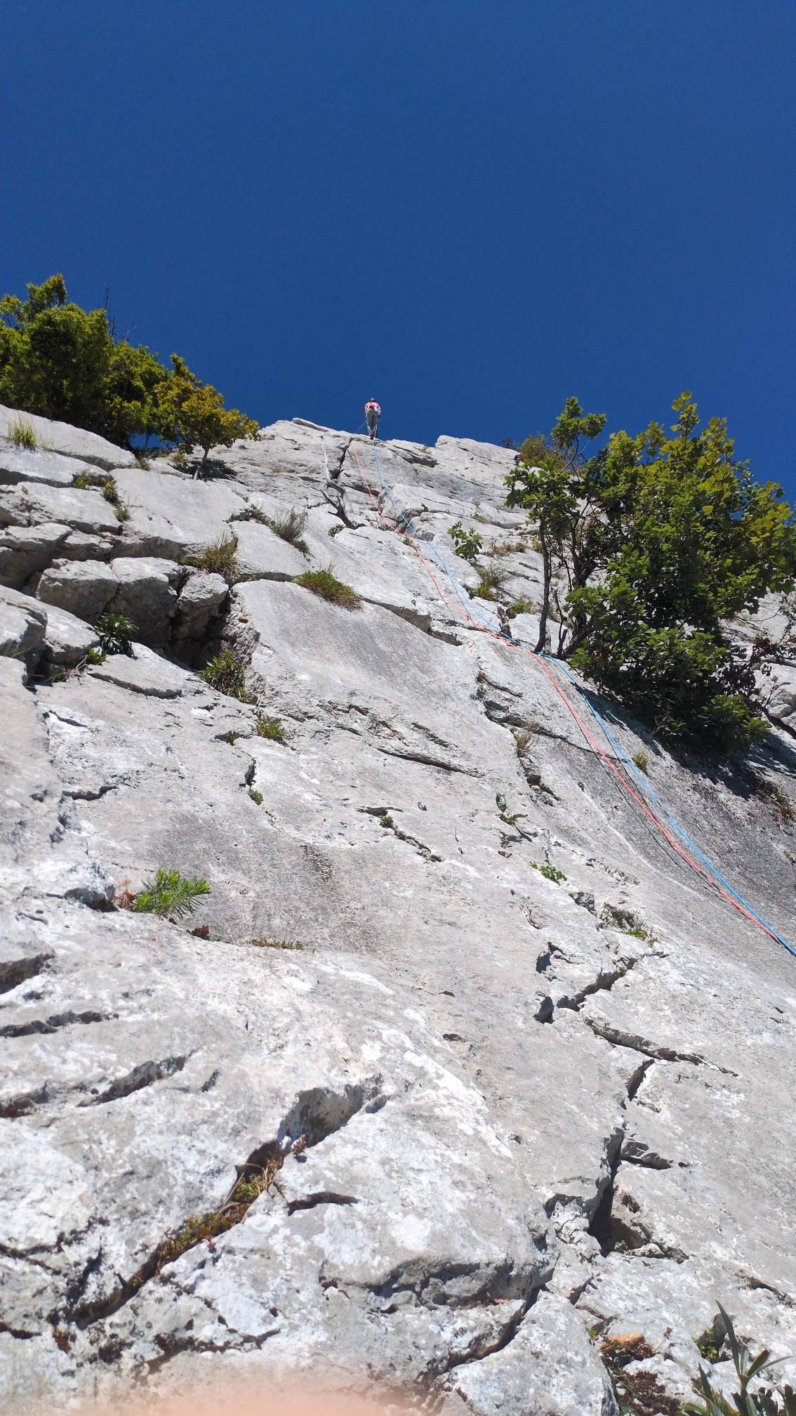 my sister in law at the top of the cliff preparing for securing my climb. Huge cracks make it nicely climbable.