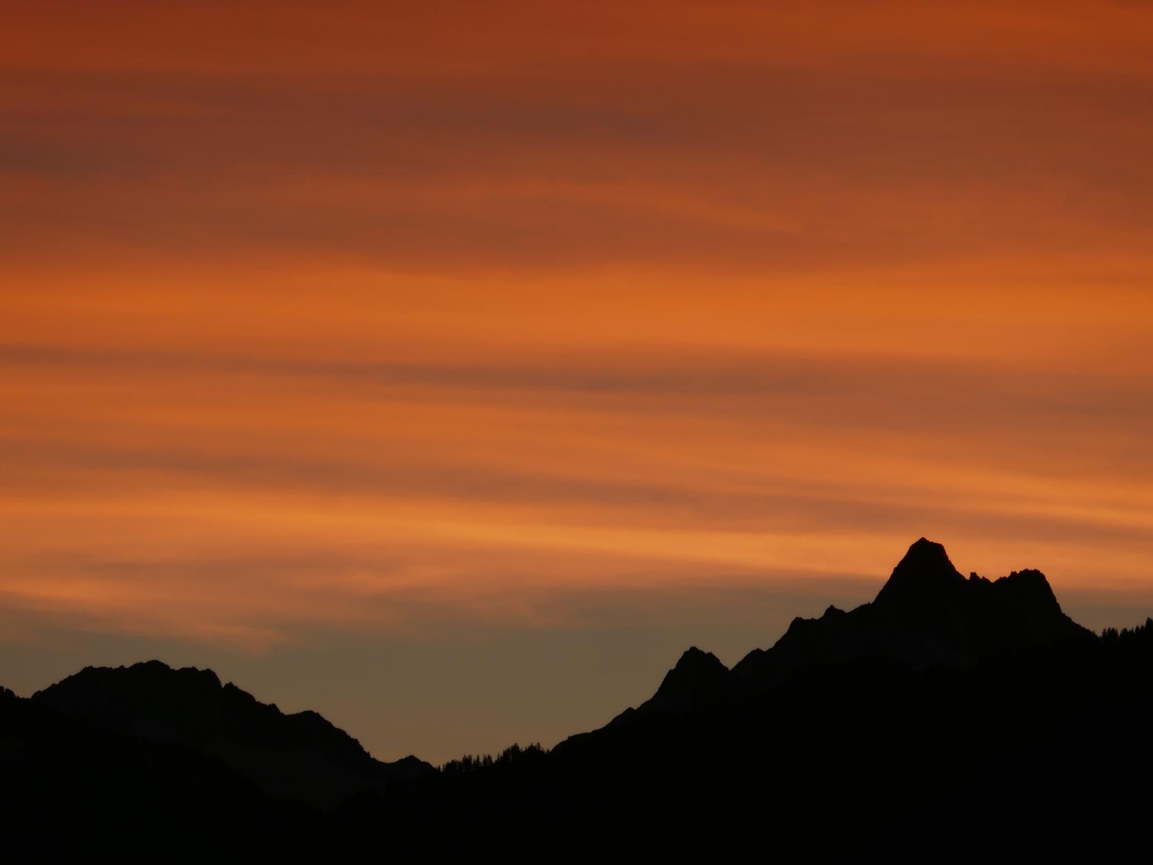 A mountain silhouette with orange sky