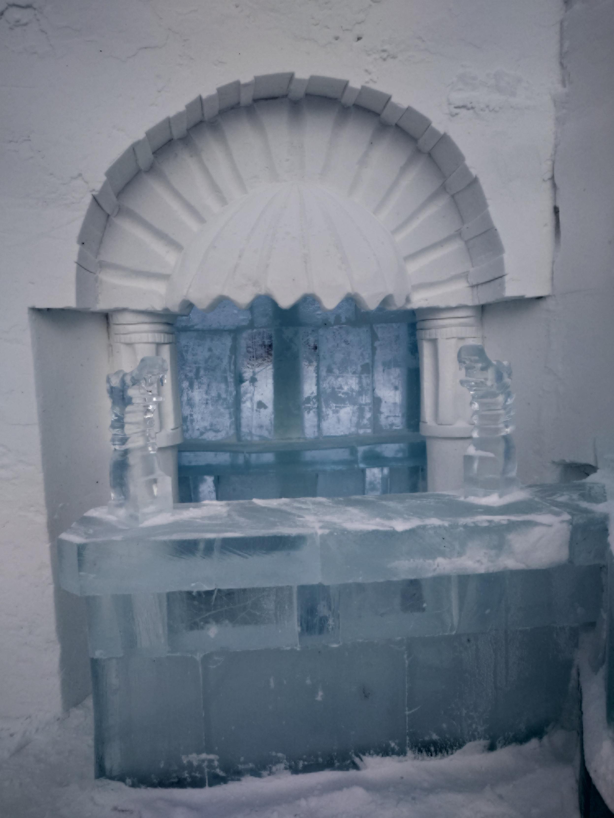 An ice bar with snow carving above.