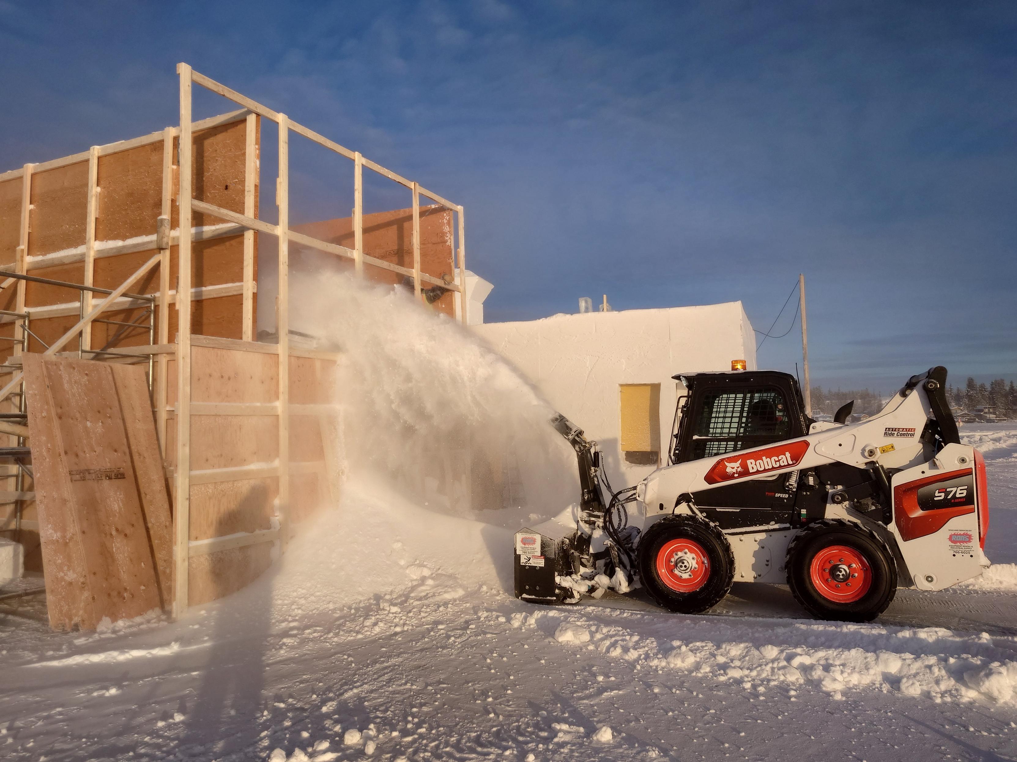 The bobcat snow blower pours a wall section.